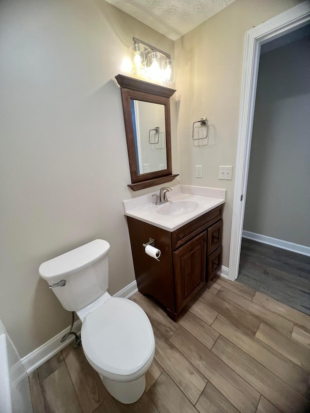 357 Carroll Eastern Rd NW, Baltimore, OH 43105 - half bathroom featuring vanity, toilet, and wood finished floors
