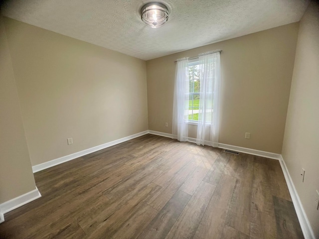 357 Carroll Eastern Rd NW, Baltimore, OH 43105 - empty room with a textured ceiling, baseboards, visible vents, and dark wood-style floors