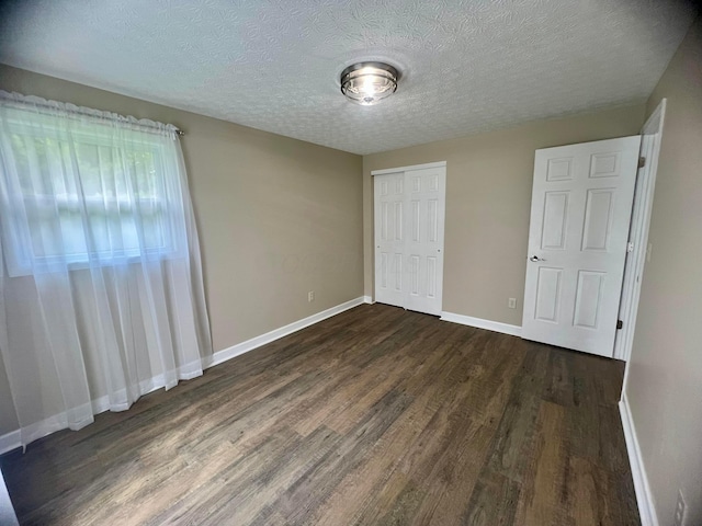 357 Carroll Eastern Rd NW, Baltimore, OH 43105 - unfurnished bedroom featuring baseboards, a closet, a textured ceiling, and dark wood-type flooring