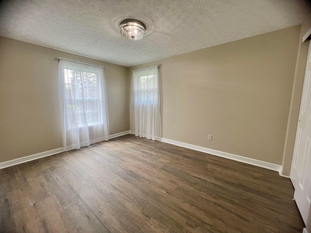 357 Carroll Eastern Rd NW, Baltimore, OH 43105 - spare room featuring baseboards, dark wood-style flooring, visible vents, and a textured ceiling