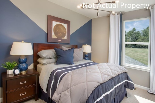 bedroom featuring an inviting chandelier, carpet floors, and baseboards