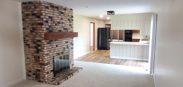 unfurnished living room featuring baseboards, a brick fireplace, and light wood-style flooring