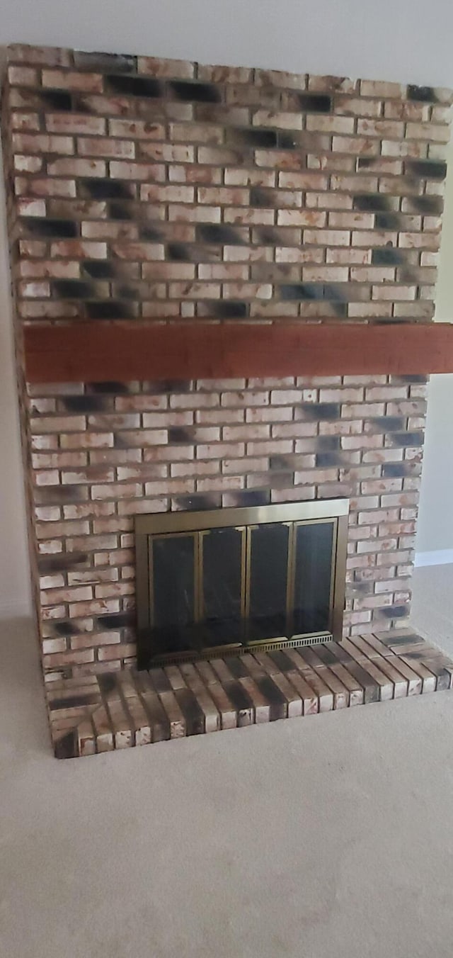 interior details featuring carpet flooring and a brick fireplace