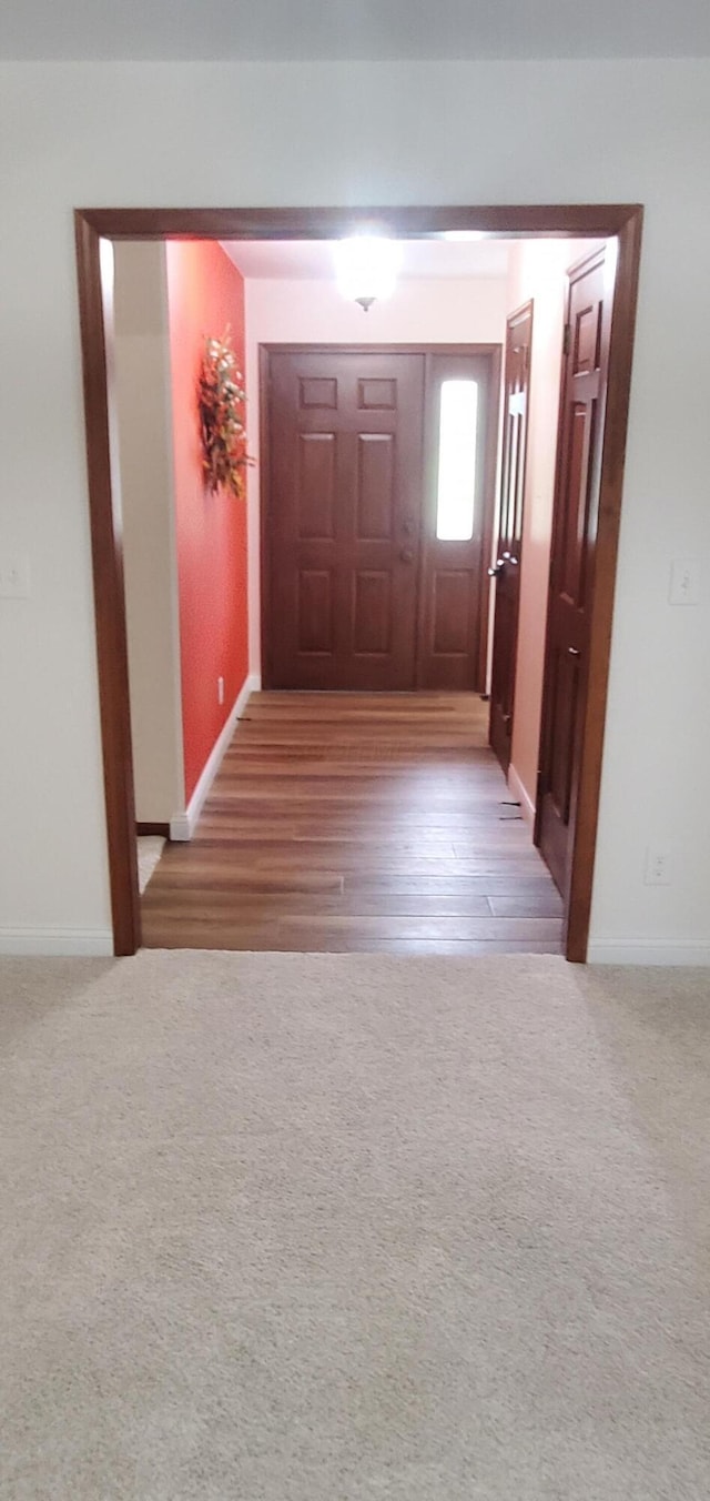 hallway featuring baseboards and carpet flooring