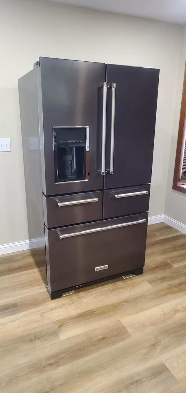 room details with baseboards, light wood-type flooring, and high quality fridge