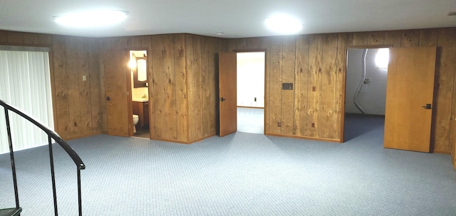 basement featuring wood walls and carpet