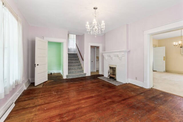 22 Elizabeth St, Delaware, OH 43015 - unfurnished living room with a brick fireplace, hardwood / wood-style floors, stairway, a baseboard heating unit, and a notable chandelier