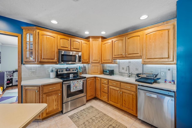1083 Martha Ave, Bucyrus, OH 44820 - kitchen featuring light countertops, appliances with stainless steel finishes, a sink, and tasteful backsplash
