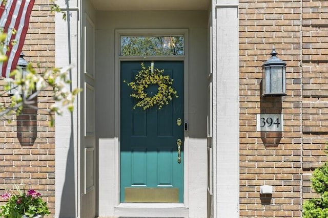 entrance to property featuring brick siding