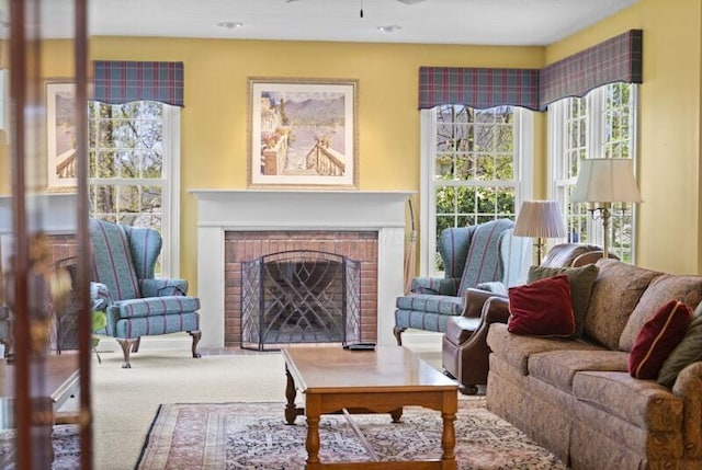 living room featuring ceiling fan, a fireplace, and carpet flooring