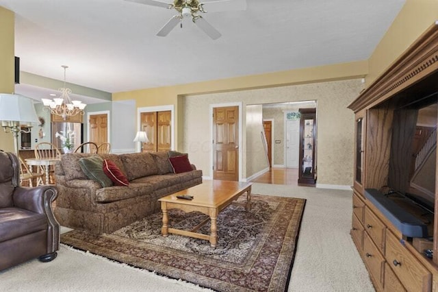 living area with baseboards, carpet, and ceiling fan with notable chandelier