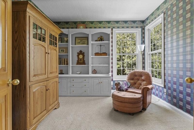 living area featuring light colored carpet and wallpapered walls