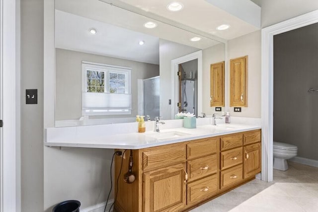 bathroom with a sink, a shower stall, toilet, and double vanity