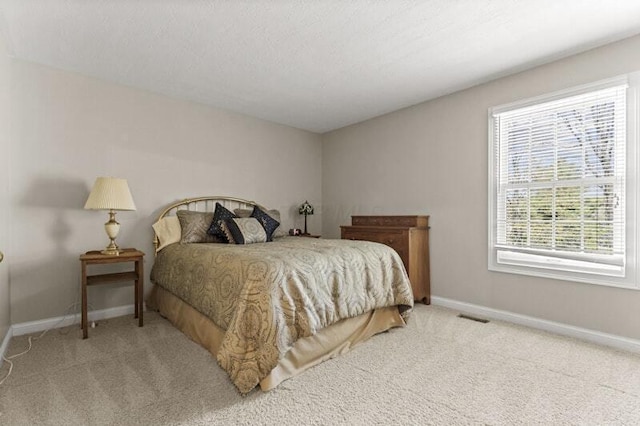 carpeted bedroom featuring baseboards and visible vents
