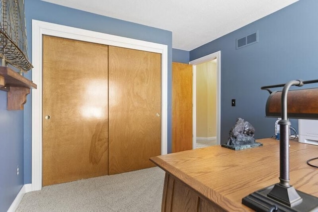 carpeted office with baseboards and visible vents