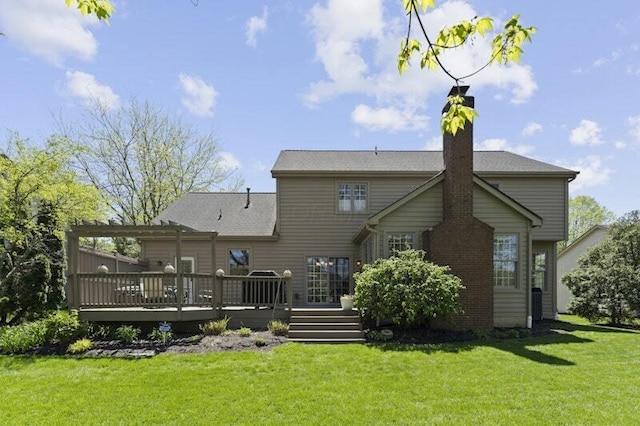 rear view of house featuring a wooden deck, a chimney, and a yard