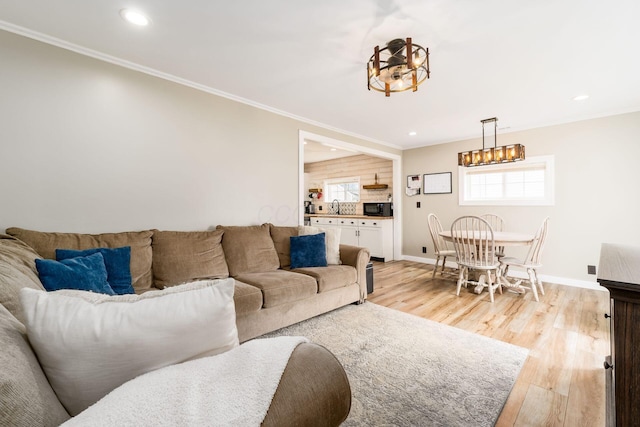 living area featuring recessed lighting, baseboards, ornamental molding, and light wood-style flooring