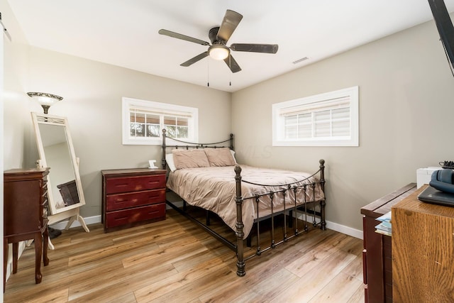 bedroom featuring visible vents, light wood finished floors, ceiling fan, and baseboards