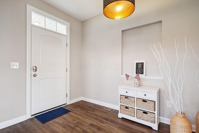 foyer entrance with visible vents, baseboards, and dark wood-style flooring