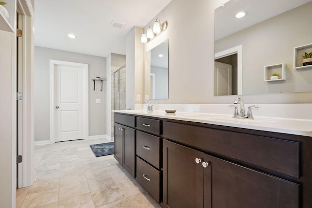 bathroom featuring a sink, baseboards, a tile shower, and double vanity