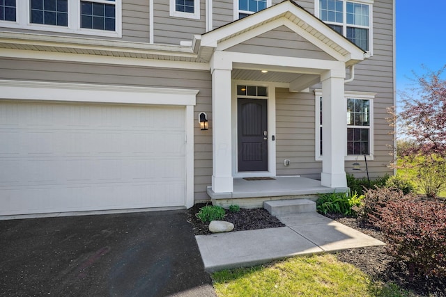 property entrance featuring a garage and aphalt driveway