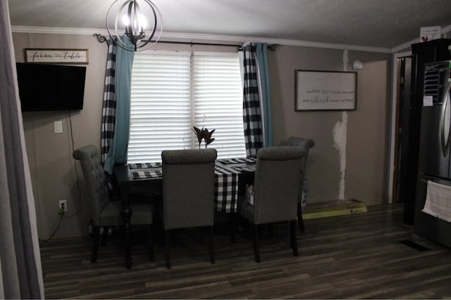 dining room with ornamental molding, wood finished floors, and a chandelier