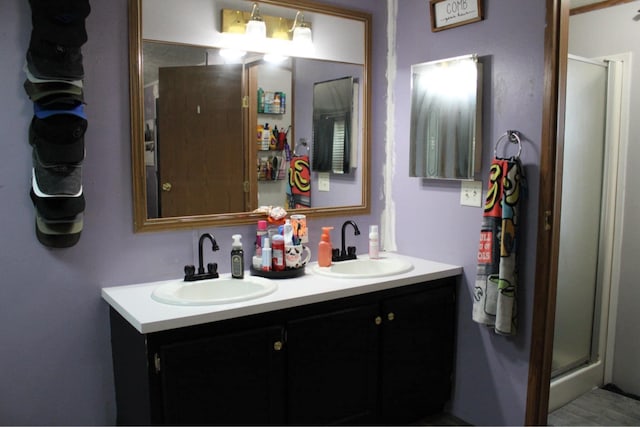 bathroom with double vanity, a sink, and a shower stall