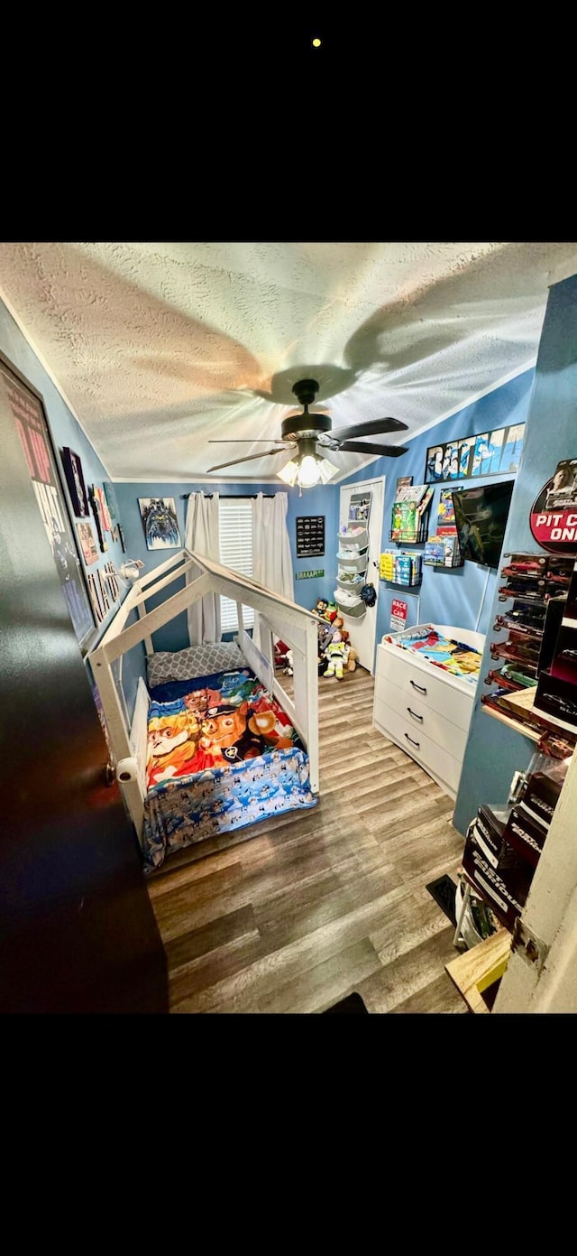 bedroom featuring a ceiling fan, a textured ceiling, and wood finished floors