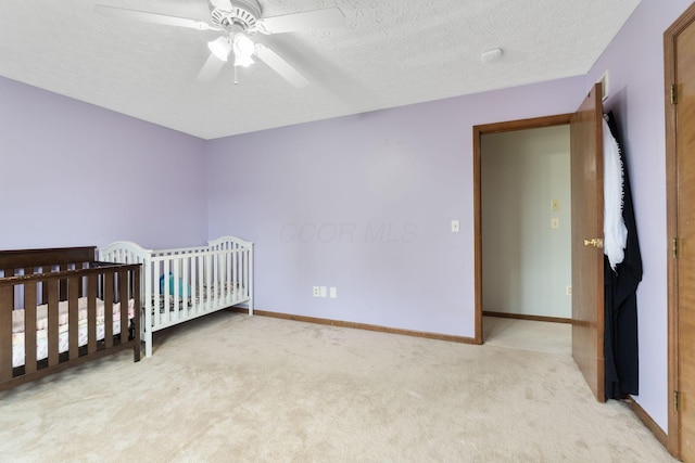 2257 Jarrow Dr, Hilliard, OH 43026 - bedroom with light carpet, a textured ceiling, baseboards, a ceiling fan, and a nursery area