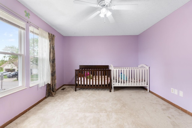 2257 Jarrow Dr, Hilliard, OH 43026 - bedroom featuring baseboards, light carpet, ceiling fan, and a nursery area