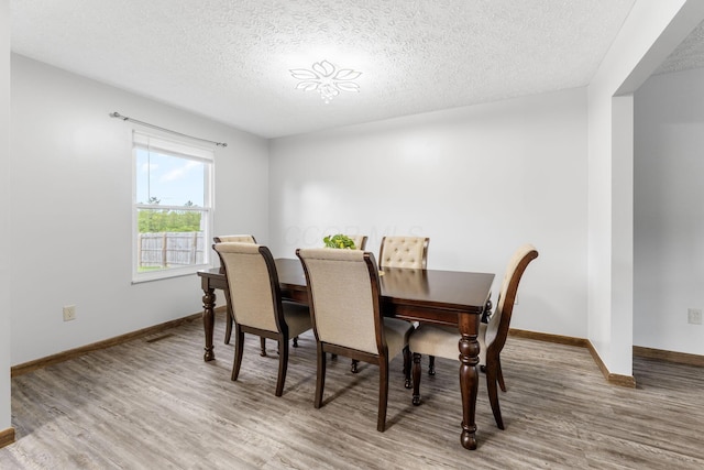 2257 Jarrow Dr, Hilliard, OH 43026 - dining room featuring a textured ceiling, wood finished floors, and baseboards