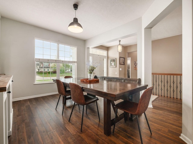 dining space with baseboards and dark wood-type flooring