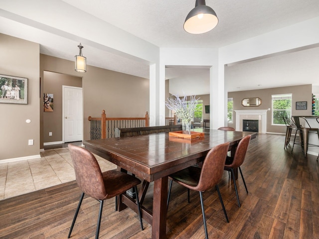 dining area featuring baseboards, wood finished floors, and a fireplace