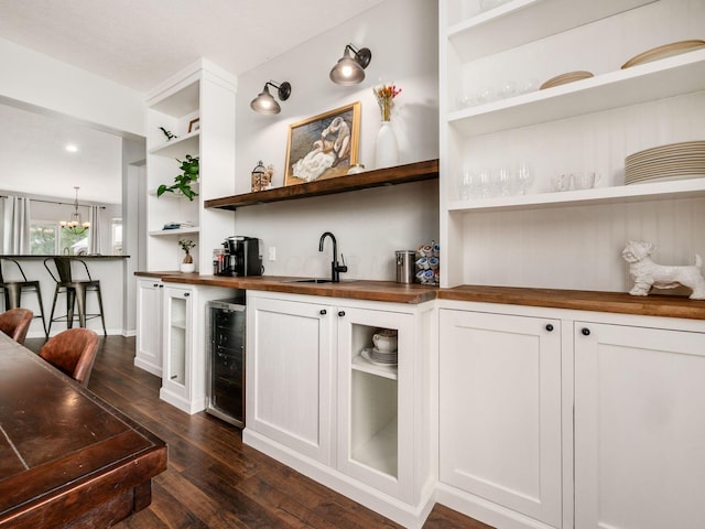 bar with wet bar, a sink, baseboards, beverage cooler, and dark wood-type flooring