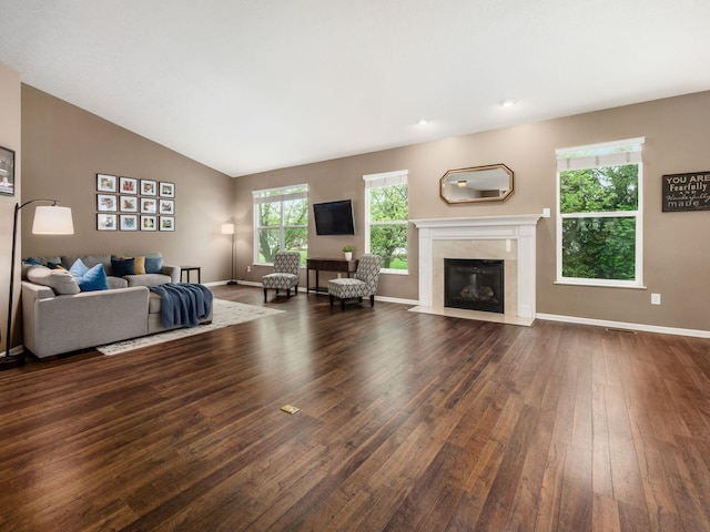 living room featuring a high end fireplace, baseboards, dark wood finished floors, and visible vents