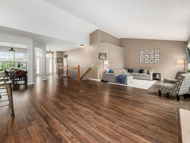 living area with baseboards, wood finished floors, and vaulted ceiling