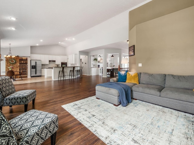 living room with an inviting chandelier, recessed lighting, light wood finished floors, and vaulted ceiling