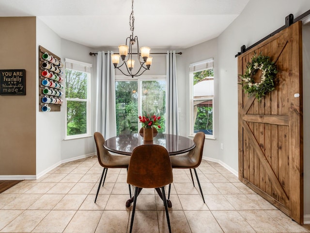 dining space featuring baseboards, a chandelier, a barn door, and a wealth of natural light