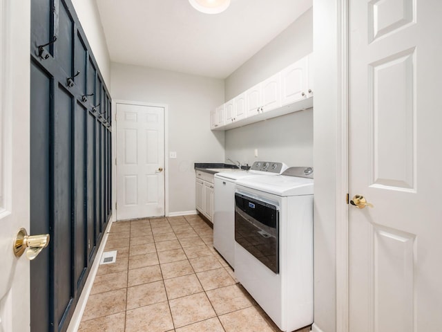 clothes washing area featuring visible vents, light tile patterned flooring, baseboards, separate washer and dryer, and cabinet space