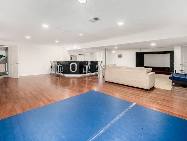 interior space with visible vents, wood finished floors, baseboards, recessed lighting, and bar