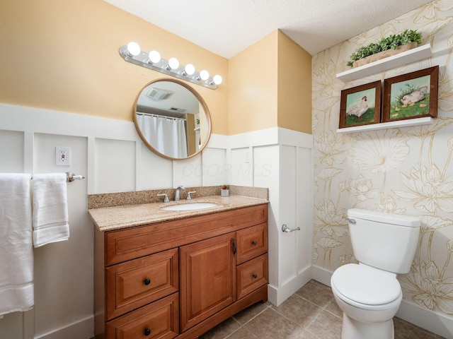 full bathroom featuring visible vents, tile patterned flooring, a wainscoted wall, vanity, and toilet