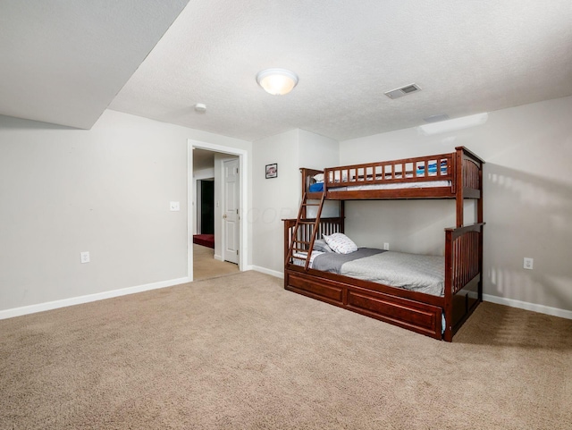 bedroom with baseboards, carpet flooring, a textured ceiling, and visible vents