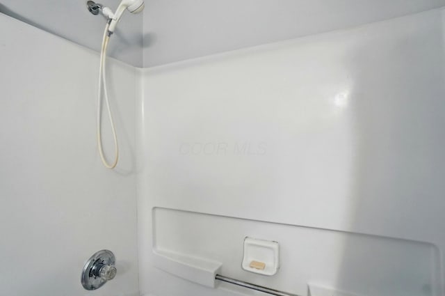interior details with bathtub / shower combination