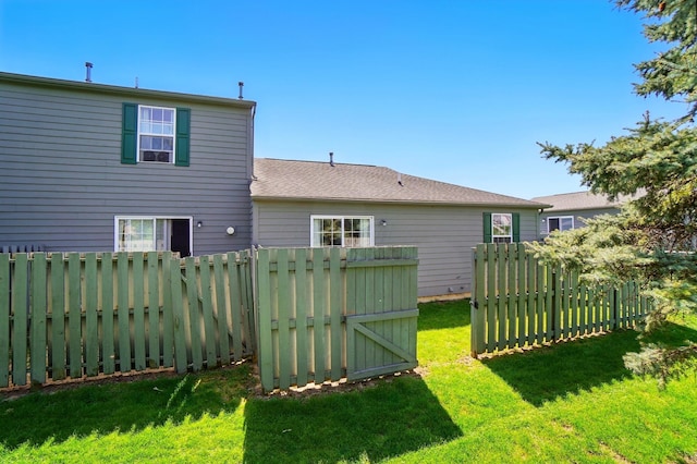 rear view of property with a lawn and fence