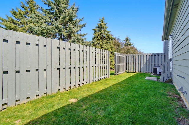 view of yard featuring fence and central AC unit