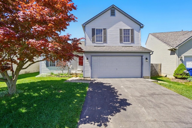 traditional home featuring an attached garage, fence, a front lawn, and aphalt driveway