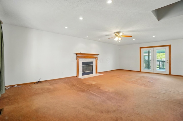 unfurnished living room featuring ceiling fan, light colored carpet, a tile fireplace, baseboards, and recessed lighting