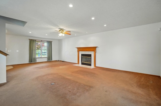 unfurnished living room featuring carpet flooring, ceiling fan, a textured ceiling, recessed lighting, and a tile fireplace