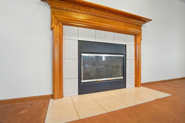 room details featuring carpet floors, baseboards, and a tile fireplace