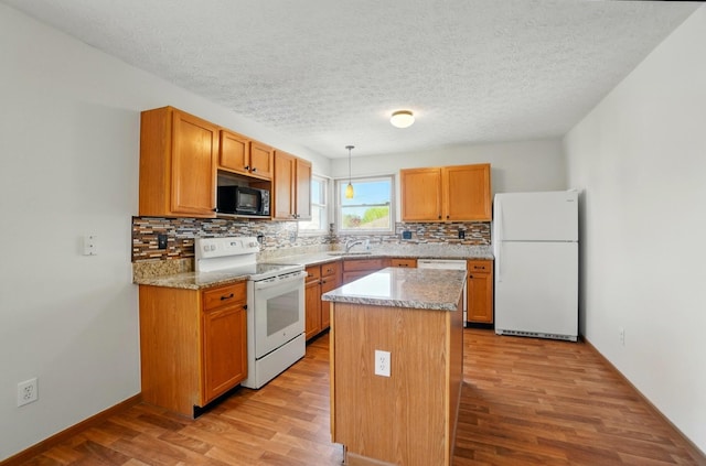 kitchen with light wood-type flooring, decorative backsplash, a kitchen island, and white appliances